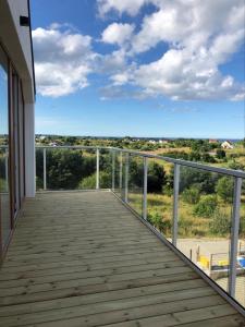 a wooden boardwalk leading to a balcony with a view at Morskie Wzgórze Apartamenty in Mechelinki