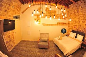 a bedroom with a bed and a chair in a room at Salah Aldin House in Acre
