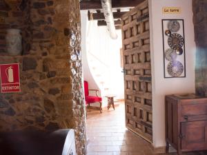 Habitación con pared de piedra y puerta en Mas Tomas, en Vall-Llobrega