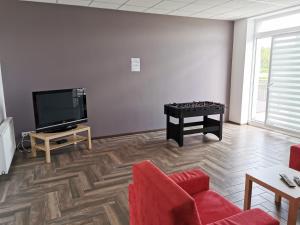 a living room with a tv and a couch and a table at Wielobranżówka in Szepietowo