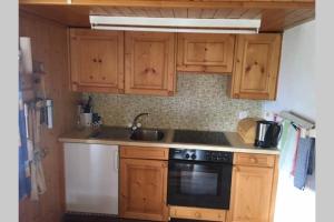 a kitchen with wooden cabinets and a sink and a stove at Idyllisches Chalet inmitten der Walliser Bergwelt in Riederalp