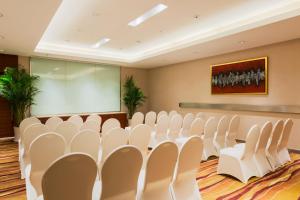 a conference room with white chairs and a screen at Holiday Inn Nanjing Aqua City, an IHG Hotel in Nanjing