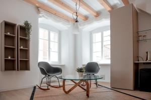 sala de estar con 2 sillas y mesa de cristal en Tergestroom & boutique apartments en Trieste