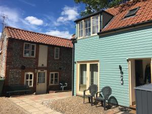 a couple of chairs sitting next to a house at Beach hut seaside cottage in Sheringham