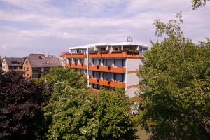 ein hohes Gebäude mit Bäumen davor in der Unterkunft Wellness Hotel Harms in Bad Nenndorf