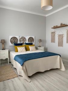 a bedroom with a large bed with blue and yellow pillows at Casal da Rita Campestre in Vaqueiros