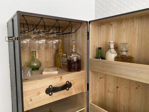 a wooden cabinet with many glass bottles on it at Casal da Rita Campestre in Vaqueiros