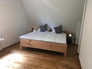 ein Bett mit zwei Kissen auf einem Zimmer in der Unterkunft Haus Tersteegen in Oberbrombach
