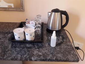 a tray with a coffee pot and cups on a counter at Hluhluwe Gate Safari Camp in Hluhluwe
