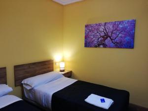 烏爾涅塔的住宿－Txokomaitea，一间卧室设有两张床,墙上挂着一幅画