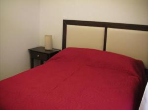 1 dormitorio con cama roja y mesita de noche en Apartamento Miramar Calle 21 en Miramar