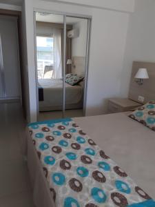 a bedroom with two beds and a mirror at Solares de Araus 203 in Colonia del Sacramento +11 photos