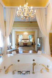 The Gastonian, Historic Inns of Savannah Collection في سافانا: حمام كبير مع حوض وغرفة معيشة