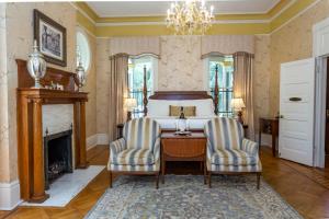 1 dormitorio con 1 cama, 2 sillas y escritorio en The Gastonian, Historic Inns of Savannah Collection en Savannah