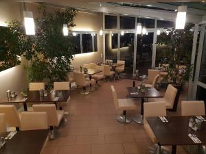 un ristorante con tavoli e sedie in una stanza di City Hotel Stuttgart a Stoccarda