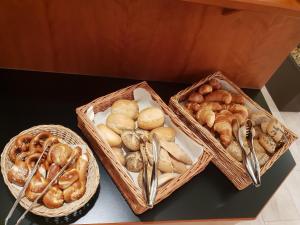 three baskets of bread and pastries on a table at City Hotel Stuttgart in Stuttgart