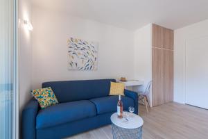 sala de estar con sofá azul y mesa en Studio Del Mar, en Saint-Cyr-sur-Mer