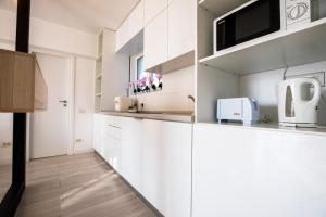 a kitchen with white cabinets and a microwave at Citadella Atheneum Apartment in Bucharest