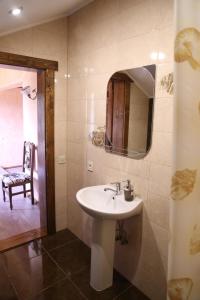 W łazience znajduje się umywalka, lustro i krzesło. w obiekcie Zatyshok v Karpatah 2 w mieście Worochta