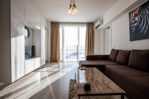 een woonkamer met een bank en een tafel bij Citadella Atheneum Apartment in Boekarest