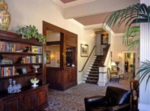 una sala de estar con una escalera y un estante de libros en Hotel La Rose, en Santa Rosa