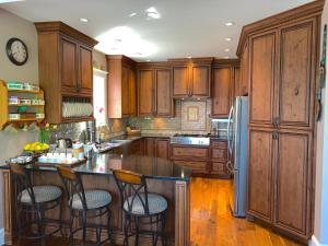 a kitchen with wooden cabinets and a island with bar stools at Eagle Rock Bed and Breakfast in Chemainus