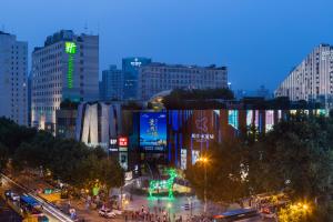 een drukke stadsstraat 's nachts met gebouwen bij Holiday Inn Nanjing Aqua City, an IHG Hotel in Nanjing