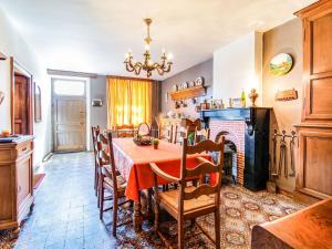 ein Esszimmer mit einem Tisch und einem Kamin in der Unterkunft Plush Holiday Home in Matagne La Petite with Private Garden in Matagne-la-Petite