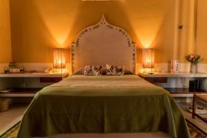 a bedroom with a large bed with a green bedspread at Hotel Boutique Casa San Angel in Mérida