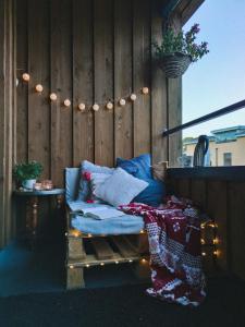 a couch sitting on a porch with a wooden wall at Maria Rooms in Kuressaare