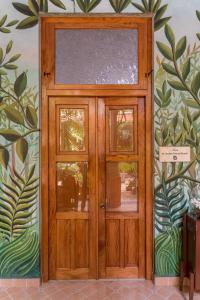 une porte en bois avec deux fenêtres sur un mur dans l'établissement Hotel Boutique Casa San Angel, à Mérida