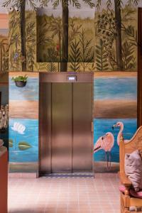 an elevator in a room with a painting of a flamingo at Hotel Boutique Casa San Angel in Mérida