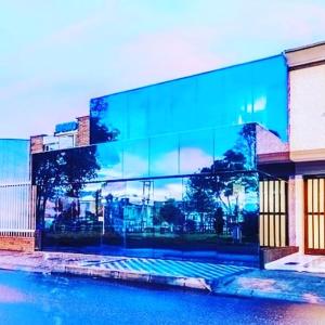 a large glass building with a reflection of a city at Hotel Boutique Markes in Bogotá