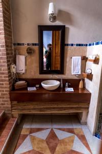 une personne prenant une photo dans un miroir de salle de bains dans l'établissement Hotel Boutique Casa San Angel, à Mérida