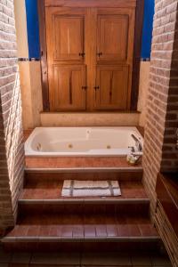梅里達的住宿－聖天使精品酒店，浴室设有木柜和浴缸