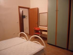 a room with a bed and a desk and a tv at trivanio semplice in Sassari