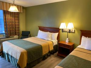 Habitación de hotel con 2 camas y ventana en Cabarrus Inn en Concord