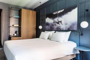 a bedroom with a large bed and a painting on the wall at Radisson Blu Hotel, Madrid Prado in Madrid