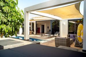 an outdoor patio with a pool and a pavilion at Casa Yuna with heated pool in El Roque in Cotillo