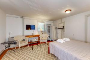 a bedroom with a bed and a desk and chairs at Sheepscot Beauty in Wiscasset