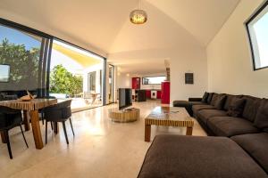 a living room with a couch and a table at Casa Yuna with heated pool in El Roque in Cotillo