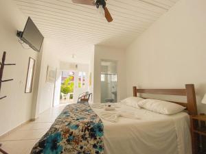 - une chambre avec un lit et un ventilateur de plafond dans l'établissement Pousada Vila Real Juquehy, à Juqueí