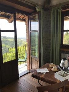 ein Zimmer mit einem Tisch und Blick auf einen Balkon in der Unterkunft Radice Verde in Cissone