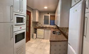 a kitchen with white appliances and a counter top at EL PUERTO CENTRO OCIO in El Puerto de Santa María