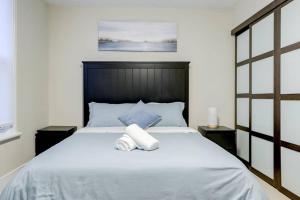 - une chambre avec un grand lit blanc et 2 tables de chevet dans l'établissement JstLikeHome - Central Suite, à Ottawa