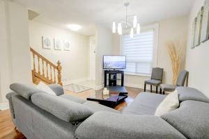 a living room with a couch and a tv at JstLikeHome - Central Suite in Ottawa