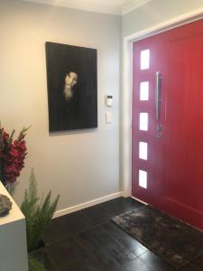 una puerta roja con una foto de un perro en la pared en Executive style bedroom en Kelburn