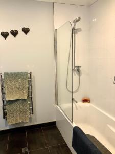 a bathroom with a shower and a bath tub at Executive style bedroom in Kelburn