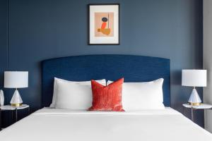 a bed with a blue headboard and red pillows at Mint House Dallas - Downtown in Dallas