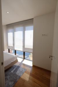 ein Schlafzimmer mit einem Bett und einem großen Fenster in der Unterkunft Apartamento en el puerto in A Guarda